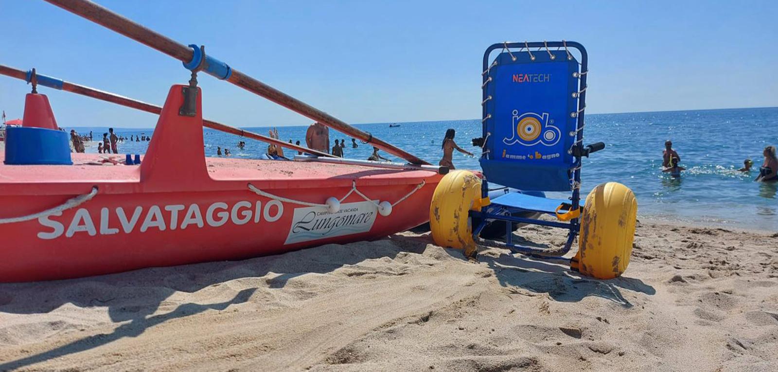 Spiaggia con barca di salvataggio e sedia da mare per disabili.